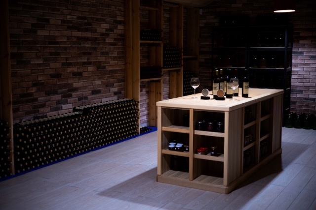 wine cellar with wooden table with bottles of wine